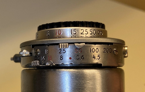 Three scales on a lens. The top one twists to adjust, while the bottom two have a slider that sits in little divot.