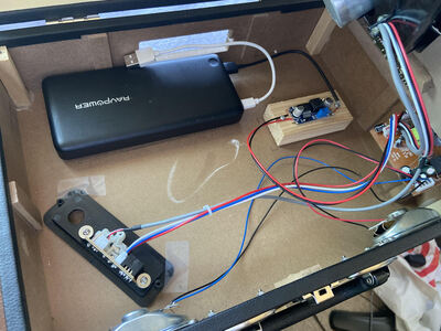 The insides of my record player, now containing a battery bank and a wood-mounted 5v to 9v converter